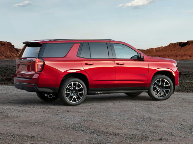A red Chevrolet Tahoe parked outside near some canyons