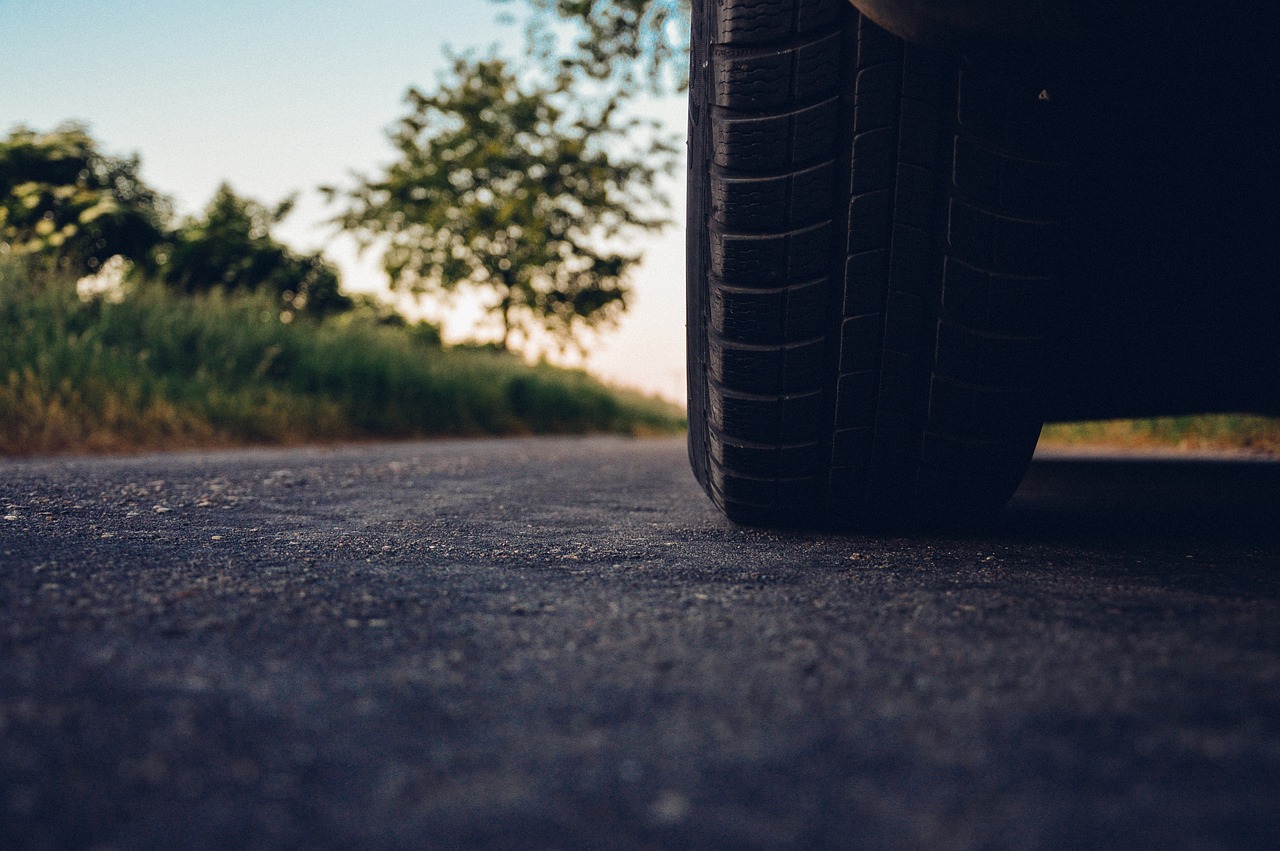 A tire parked on a road near a tree