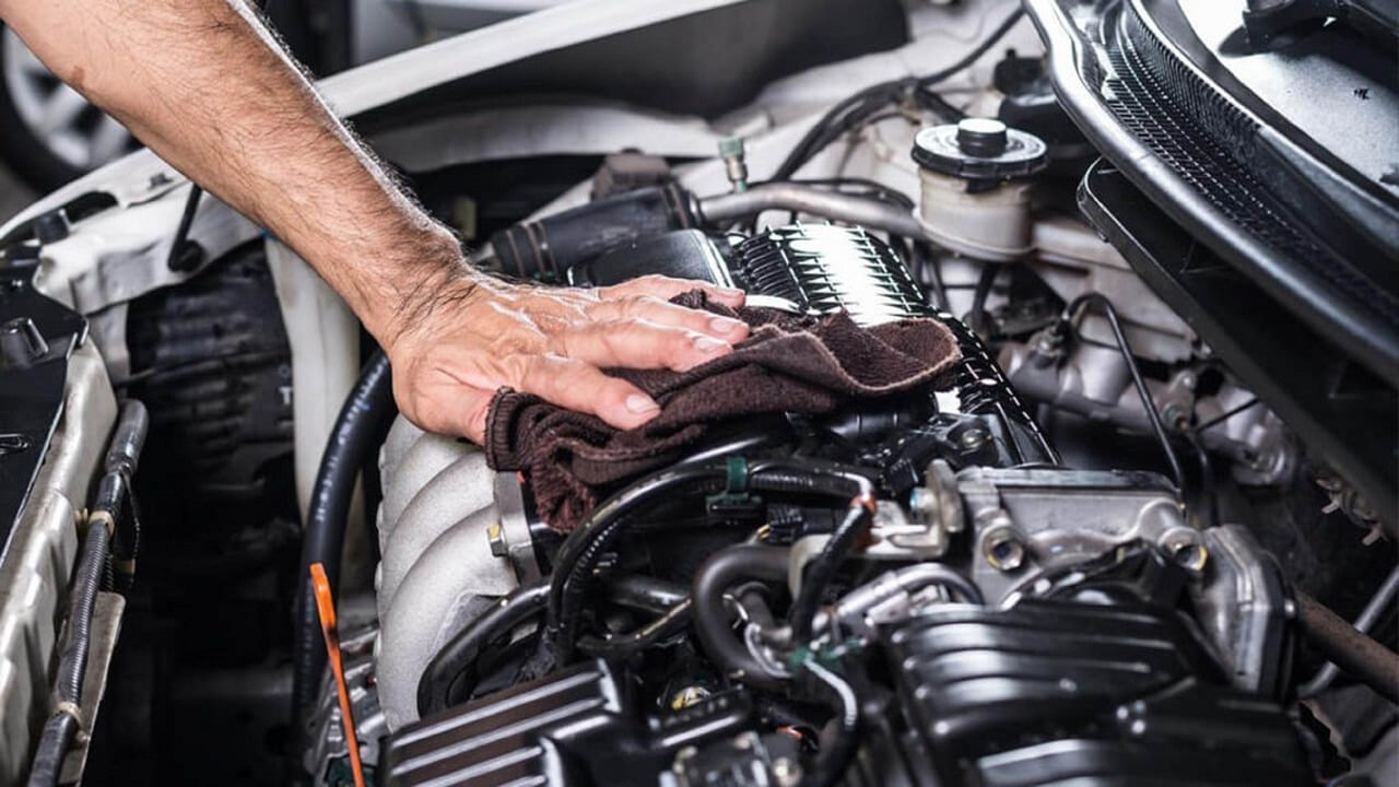 A person working under a car's hood
